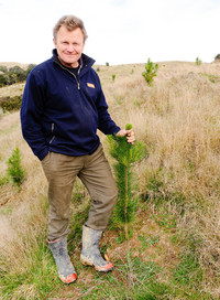 Farmer with his new trees.  Photo from Mark Coote/Bloomberg 